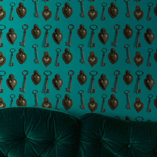 pattern of sacred hearts and keys on jade background shown as wallpaper with green sofa