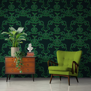 pattern of entwined green snakes on a dark background shown as wallpaper with green chair and sideboard