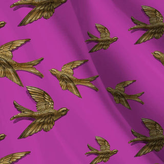 pattern of gold birds on a pink background shown as fabric